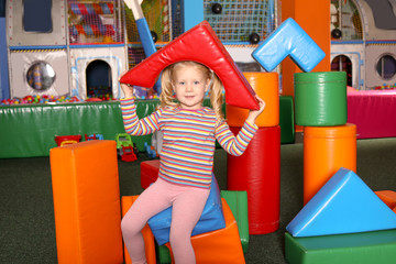 Fototapeta na wymiar Cute child playing with colorful building blocks indoors