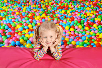 Fototapeta na wymiar Cute child playing in ball pit indoors