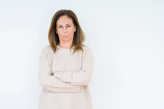 Beautiful middle age woman over isolated background skeptic and nervous, disapproving expression on face with crossed arms. Negative person.