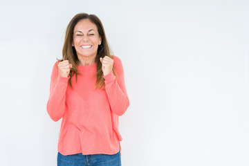 Fototapeta premium Beautiful middle age woman over isolated background excited for success with arms raised celebrating victory smiling. Winner concept.
