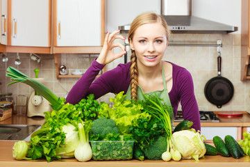 Woman in kitchen with green vegetables