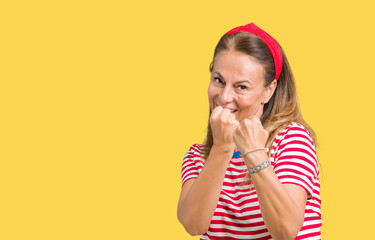 Beautiful middle age woman wearing casual stripes t-shirt over isolated background Ready to fight with fist defense gesture, angry and upset face, afraid of problem