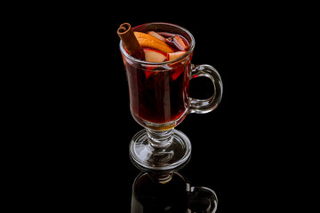 Mulled wine on a black background with reflection