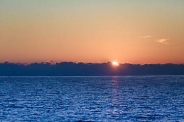 Fototapeta na wymiar Sunrise or sunset over sea surface