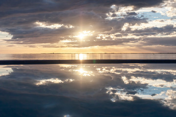 Obraz premium amazing sunset over the sea with dramatic clouds pool reflection