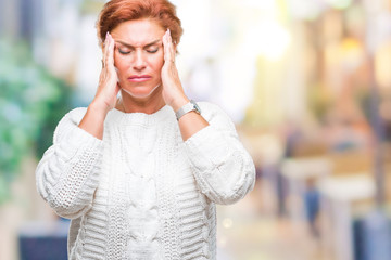 Atrractive senior caucasian redhead woman wearing winter sweater over isolated background with hand on head for pain in head because stress. Suffering migraine.