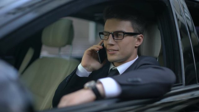 Successful businessman talking on phone with boss as sitting in car, good news