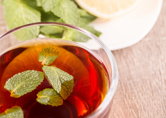 The tea cup with mint on old wooden background
