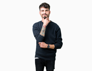 Young handsome man over isolated background looking confident at the camera with smile with crossed arms and hand raised on chin. Thinking positive.