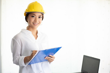 Asian women engineering inspecting and working and holding blueprints at office
