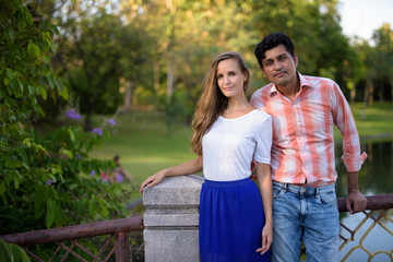 Fototapeta premium Multi ethnic couple standing together on the bridge of peaceful 