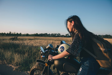 Fototapeta na wymiar Young sexy woman on a motorcycle in nature on the sunset.Travel Concept.
