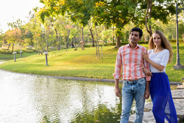 Fototapeta premium Multi ethnic couple thinking while standing on stone path in the