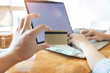 Woman hand holding credit card and using laptop to search web site for online shopping.