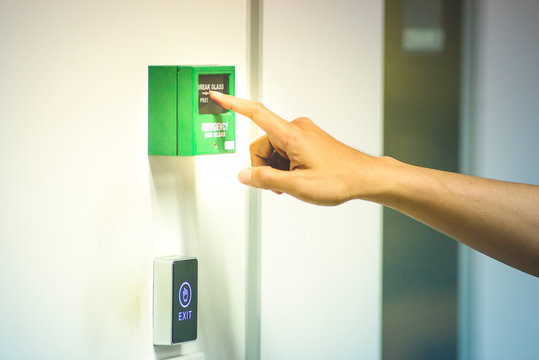 Finger pressing on emergency door release to open the door during power outage.safety concept (Soft focus)