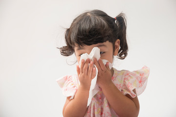 Asian little girl with handkerchief. Sick child has runny nose isolated on white background