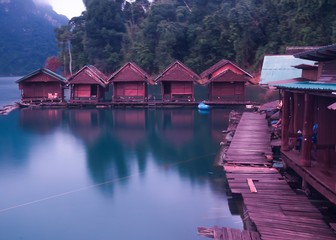 Fototapeta premium Morning at Floating house in Cheow Lan Dam or Ratchaprapa Dam,Thailand. (Soft focus with film grain)