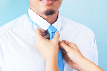 Wife tying necktie of her husband, Close up shot, Asian man with beard