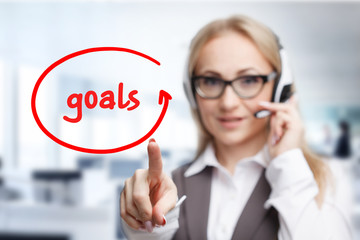 Technology, internet, business and marketing. Young business woman writing word: goals