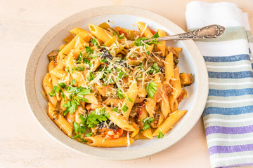 Pasta caponata on a plate on a light rustic table