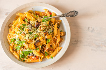 Pasta caponata on a plate on a light rustic table. Recipe copy space
