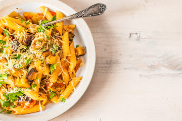 Pasta caponata on a plate on a light rustic table. Recipe copy space