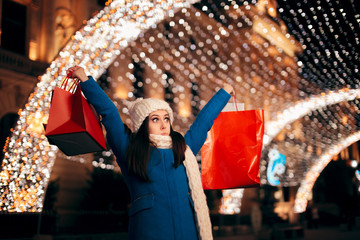 Happy Girl Holding Shopping Bags on Christmas Lights Décor