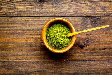 Japanese matcha tea tradition. Matcha accesories near matcha powder in bowl on dark wooden background top view copy space