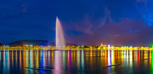 Sunset view of Geneva dominated by Jet d'eau fountain and Saint Pierre Cathedral, Switzerland
