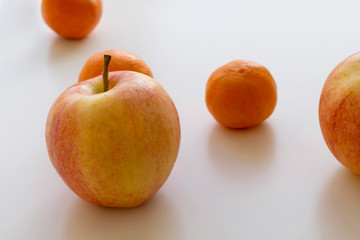 Apples and mandarins on the white table. Close-up, soft focus, copy space