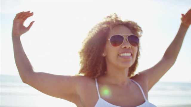Portrait of attractive voluptuous carefree Ethnic African American female relaxing and smiling in a sundress and aviator sunglasses 