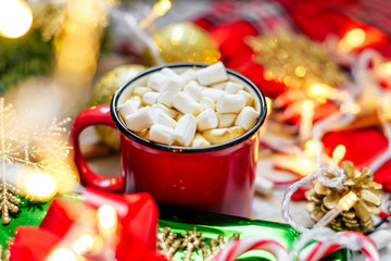 Christmas. Christmas background. Happy New Year. Holiday Red mug with hot chocolate white marshmallows and candy in the shape of a Christmas tree. Selective focus.