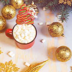 Christmas. Christmas background. Happy New Year. Holiday Red mug with hot chocolate white marshmallows and candy in the shape of a Christmas tree. Selective focus.