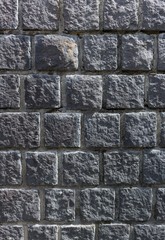 Naklejka premium Old dark grey stone wall background texture