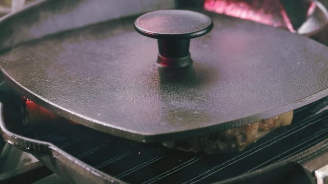 Pork T-Bone steak. Frying pan with covered lid