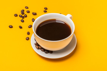 Spilled coffee beans on a bright yellow background