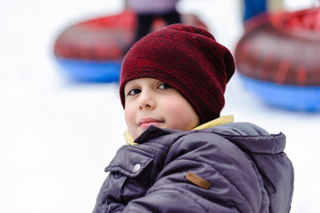 The boy is riding a tubing, portrait, close-up