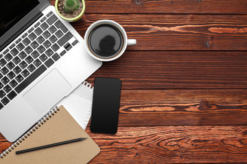 Office supplies and equipment on dark wooden table, top view