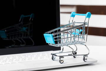 shopping online concept. small toy trolley and gadgets on the table