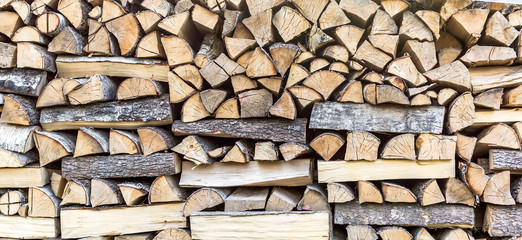 Wood pile texture. Chopped wood piled in a wood stack and prepared for heating in winter. Cut firewood for winter. Background of wooden logs.