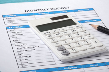 Calculator on monthly budget sheet - obrazy, fototapety, plakaty