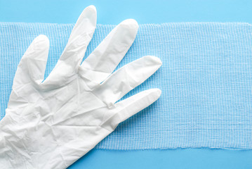 White medical glove on a bandage. Sterile bandage on blue. Medical equipment on blue.
