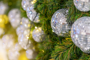 Group of silver and gold balls hanging on pine branches