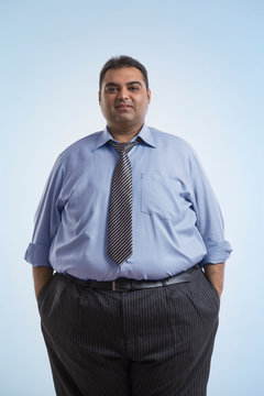 Portrait of obese man in formal clothes standing with hands in pocket