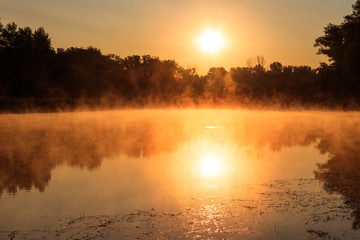 View of river in the mist at sunrise. Fog over river at morning