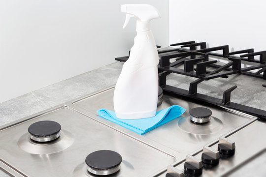 Cleaning a gas stove with kitchen utensils, household concepts, or hygiene and cleaning.