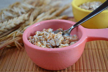 Useful five-grain porridge and wheat ears on wooden background.