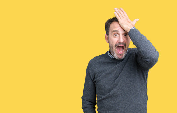 Handsome middle age senior man wearing a sweater over isolated background surprised with hand on head for mistake, remember error. Forgot, bad memory concept.