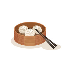 Xiao long bao or steamed dumplings in wooden container and chopsticks. Traditional dish of Malaysian cuisine. Culinary theme.