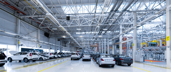 Park cars. building of automobile plant. New cars are in showroom